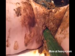 A scat whore uses cucumbers to masturbate while shitting herself.